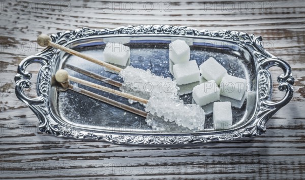 White sugar cubes sticks tray on vintage wooden board