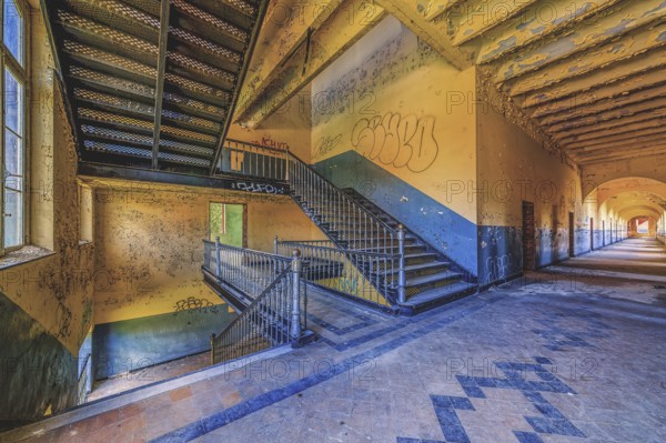 Long, deserted corridor with stairs and graffiti on the walls, Prison H11, Lost Place, Verviers, Province of Liège, Belgium, Europe