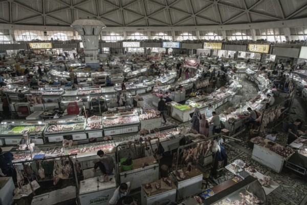 05-13-2022 Tashkent, Uzbekistan. Eastern meat market (Tashkent) in the Hall (pavilion) . Lots of merchants and buyers. High viewing angle