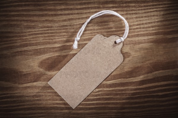 Vintage paper price tag label on old wooden boards close up
