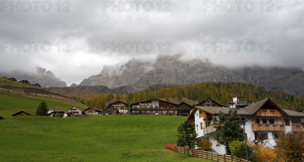 Costadedoi, Italy, October 19 2019: Traditional wooden cottage mountain houses in the green field in the dolomites. Housing in costadedoi Italian apls. Alpine region, Europe