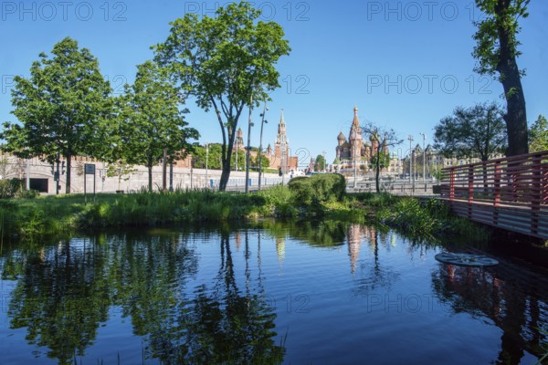 Zaryadye park and Kremlin fortress and St. Basil 's Cathedral in Moscow with pond and reflections, amazing summer