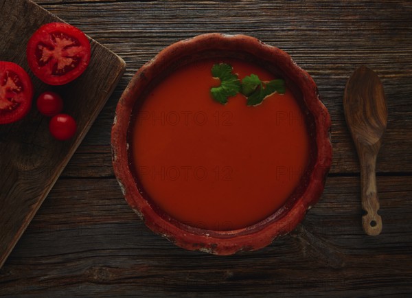 Tomato sauce on clay dish and dark wood background
