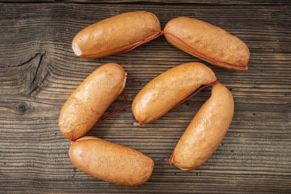 Smoked sausages on dark rustic wooden background