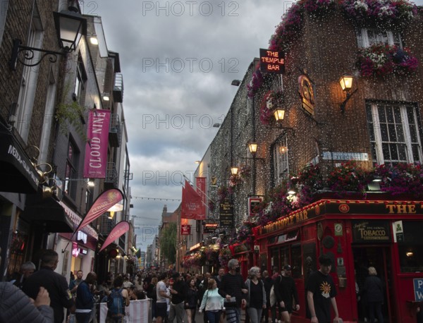 Ireland, Dublin, June 20 2022: People outside the famous Irish pub The Temple Bar in the centre of the Irish capital, men women tourists citizens walking, Europe