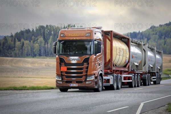 Scania S730 truck of AH-Trans Oy hauls four chemical tank containers on road, ADR codes denoting Sodium. Long transport. Salo, Finland. May 15, 2021