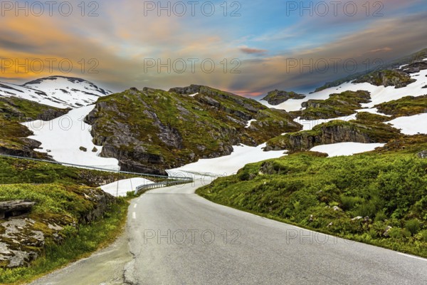 The road to Lake Djupvatnet. The mountains are covered with freshly fallen snow. Summer trip to Norway. The road to the palace of the Snow Queen. Magical places in Norway