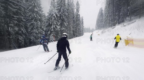 People skiing on the snowy slope of Bukovel ski resort in the Ukrainian Carpathian mountains