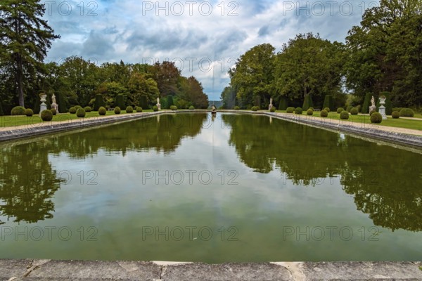 France. Thepossession of Puss in Boots. Huge rectangular swimming pool with a fountain in the park. Beautiful park surrounds the ancient castle of Breteuil