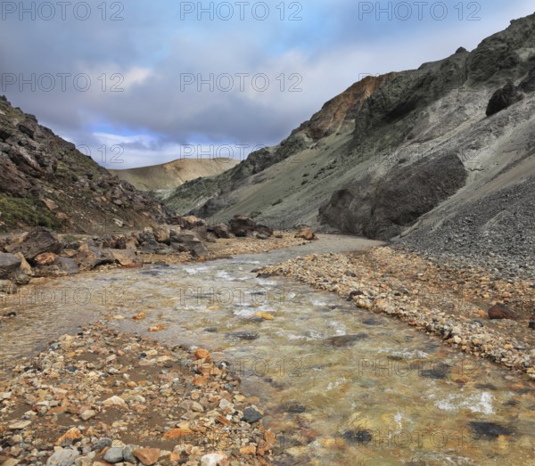 National Park Landmannalaugar in Iceland. Creek in the gorge between the mountains of black volcanic ash