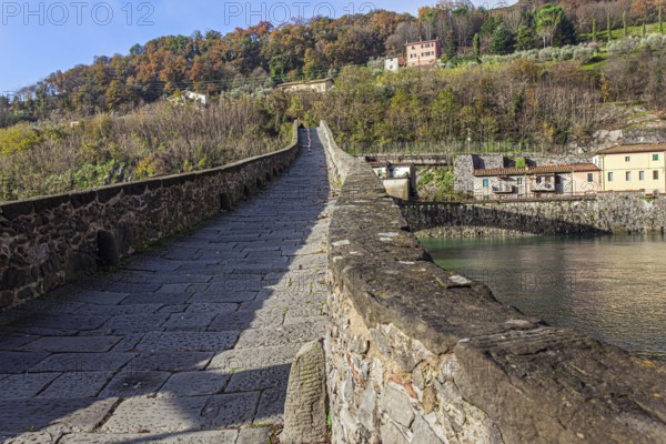 Picturesque stone bridge built a thousand years ago. Devil's Bridge over the Sercchio River. Cold windy winter day. Travel to fabulous Italy