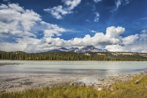 Beneaped Medicine Lake in the fall. Evergreen forests and snow-capped Rocky Mountains of Canada