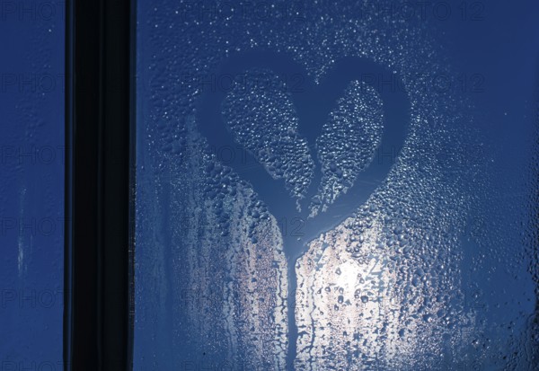 Moonlight through the window. Sweaty glass and heart shape