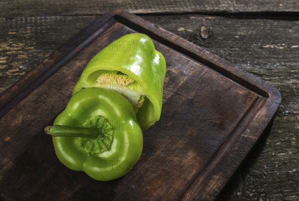 Cut green pepper on wood. Backlight