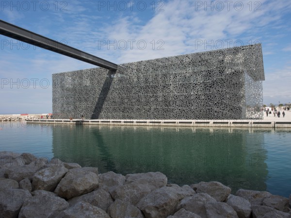 Metal decorated modern building in a watery environment under a blue sky, marseille, mediterranean sea, france