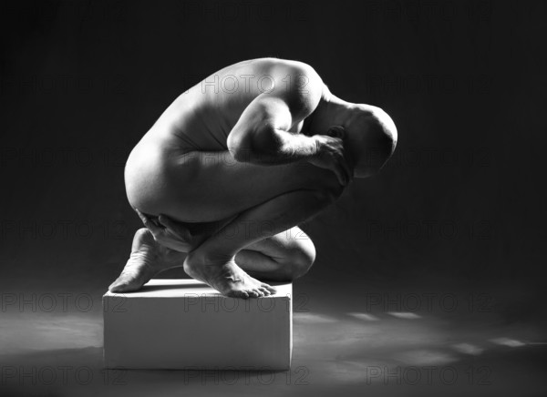 Studio portrait of athletic man. Body sculpture. Monochrome photo