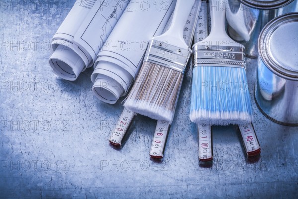 Top view of paint brushes cans construction drawings wooden meter
