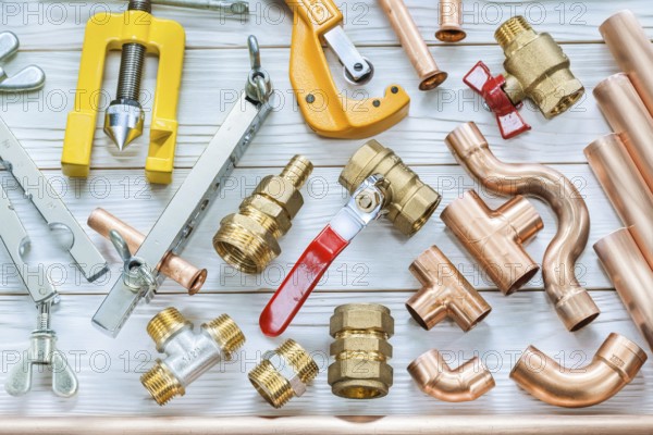 Plumbing tools copper pipes pipe cutter fittings valwes flaring clamps on white wooden boards