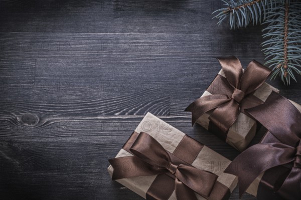 Pine branch packed present box on wooden board holiday concept