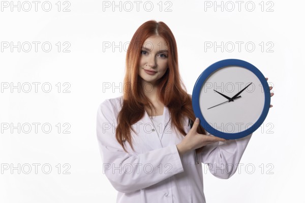 A young woman wearing a lab coat is showcasing a clock, which symbolizes the importance of effective time management