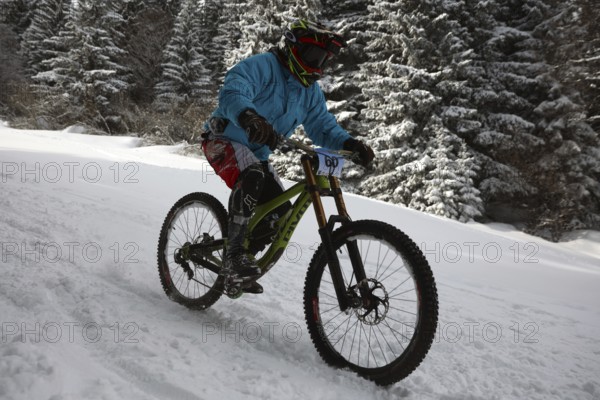 Sofia, Bulgaria - 22 January, 2022: Cyclist rides a bike downhill during an extreme snow riding mountain bicycle competition in Vitosha mountain