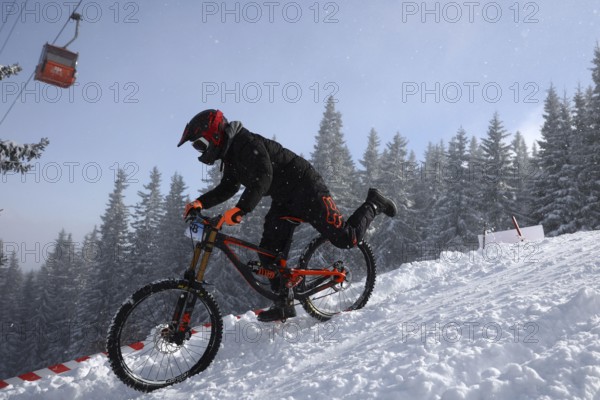 Sofia, Bulgaria - 22 January, 2022: Cyclist rides a bike downhill during an extreme snow riding mountain bicycle competition in Vitosha mountain