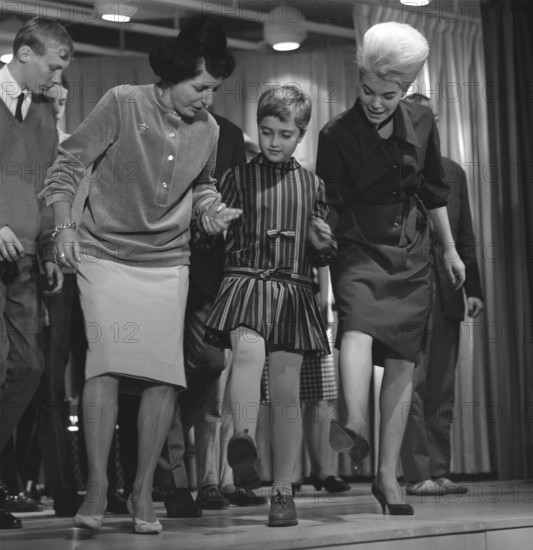 Dancing in the 1960s. The dance Hully Gully is being made popular and here are men and women dancing the new craze. Hully Gully was a type of unstructured line dance and consisted of a series of steps and was relatively simple and easy to execute. Hully Gully can be seen performed by actor John Belushi in the film Blues Brothers. Notice the typical BeeHive hairdo on the girl to the right. Picture taken 1963