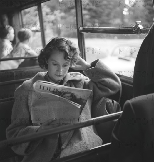 Woman in the 1950s. A young woman on a bus ride spends her time reading a magazine. Sweden 1952. Kristoffersson Ref BG81-8