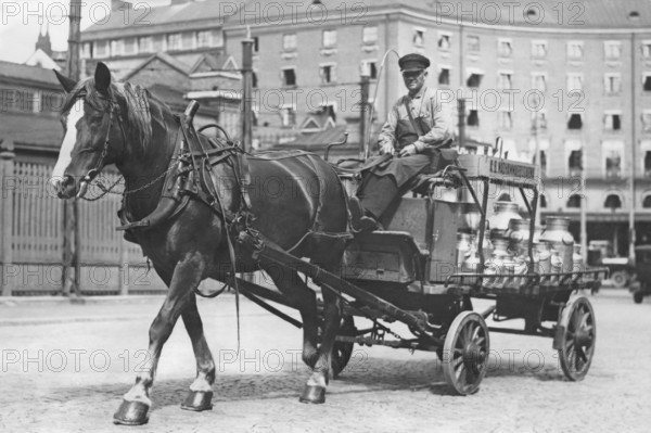 In the 1930s. A horse and carriage pictures in a Stockholm street 1936. The horse-drawn cart has a load of large milk bottles