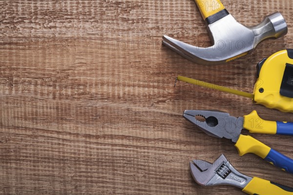 Set of tools hammer tapeline pliers wrench on vintage wooden board with copysapce construction concept