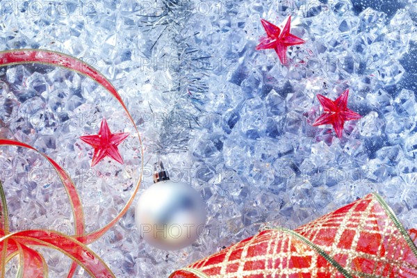 Christmas silver bauble and red ribbon on ice with red star