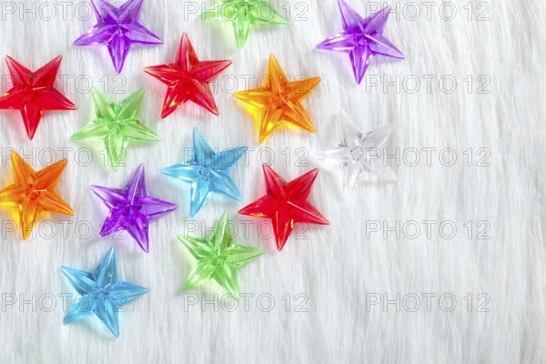 Christmas colorful glass stars over white fur background as snow