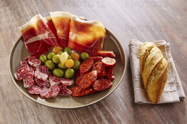 Tapas of Spain with ham bread olives sausage and chorizo on wooden background