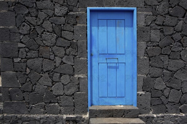 Blue door in black lava stone masonry wall at La Palma Canary Islands