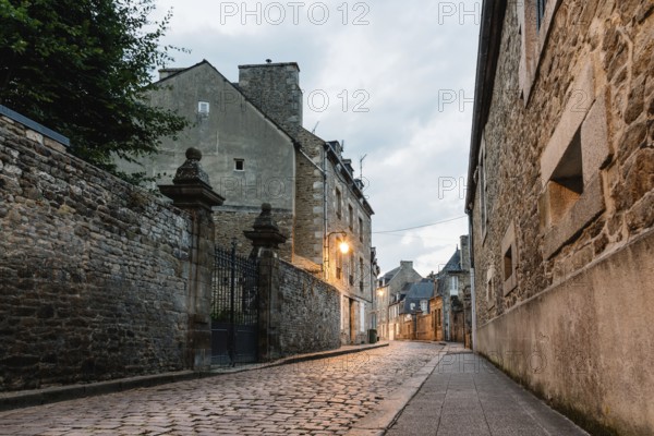 Old cobblestoned street with stone medieval houses in the town centre of Dinan, French Brittany