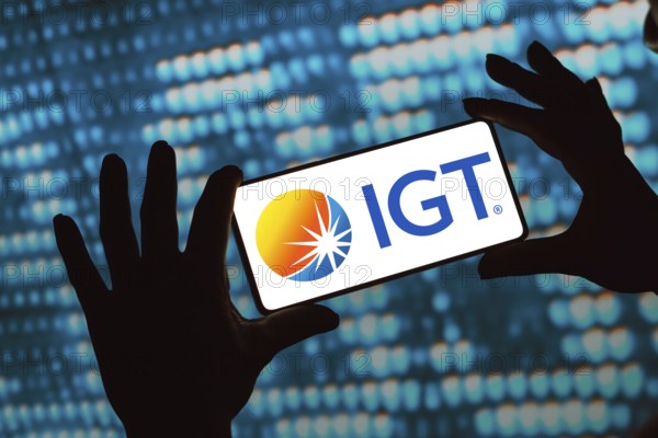 In this photo illustration, the International Game Technology (IGT) logo is displayed on a smartphone screen