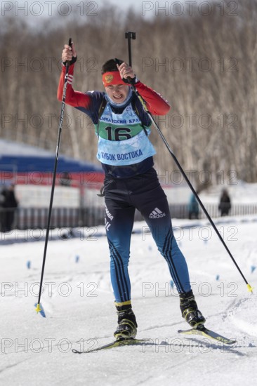 Sportsman biathlete Kapustin Aleksandr skiing on ski track distance biathlon stadium during Junior biathlon competitions East Cup. Petropavlovsk, Kamchatka Peninsula, Russian Far East, April 14, 2019