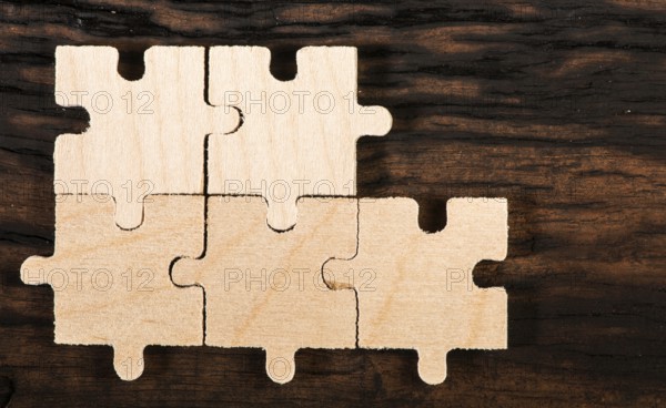 Wooden puzzle on dark wooden background