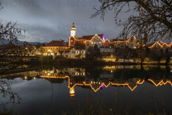 Christmas illuminated house facade of Frohnleiten reflected in the river Mur, Frohnleiten, Styria, Austria, Europe