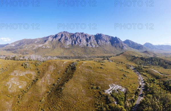 An aerial view of Gordon River Rd at the Sentinel range of mountains near Bitumen Bones Sculpture on a hot summer's afternoon in Southwest National Park, Tasmania, Australia, Oceania