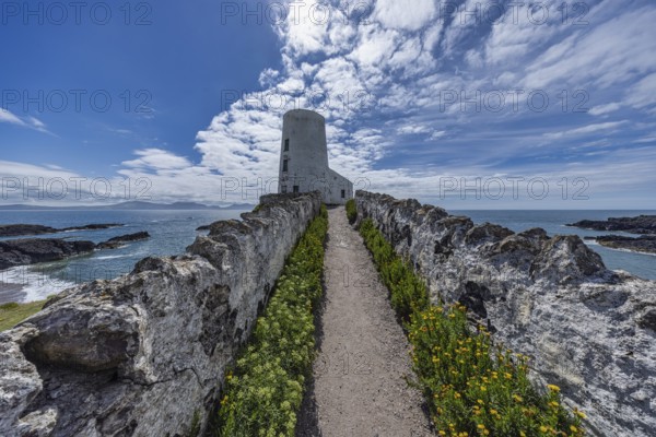 Twr Mawr Lighthouse, white lighthouse by the sea with blue sky and clouds, Ynys Llanddwyn, Newborough, Anglesey, Wales, Great Britain