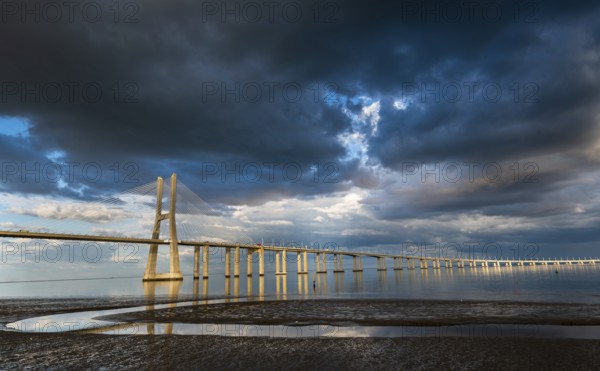 Vasco da Gama Bridge at sunset with dramatic cloudy blue sky in Lisbon, Portugal, Europe