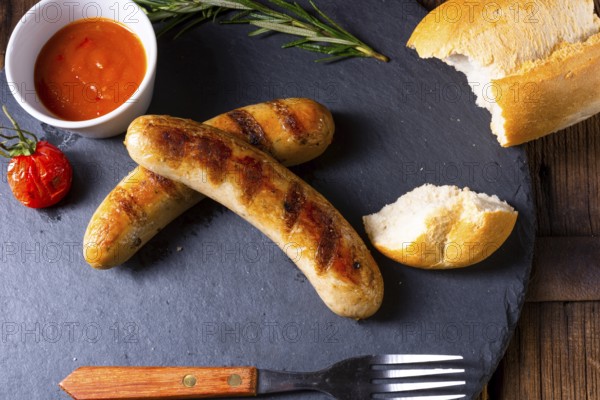 Rustic bratwurst with ketchup and fresh rolls