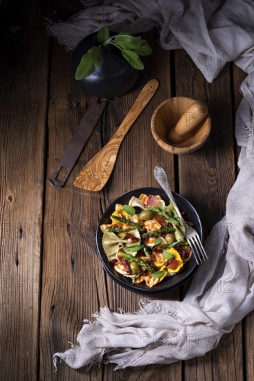 Pasta salad with green asparagus, olives and Parma ham