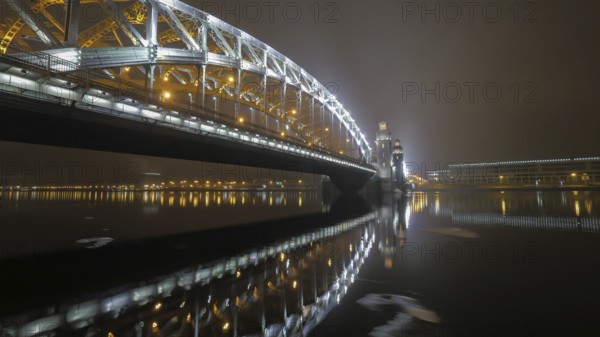 Illuminated Peter the Great Bridge across Neva River in night Saint Petersburg, Russia, Europe