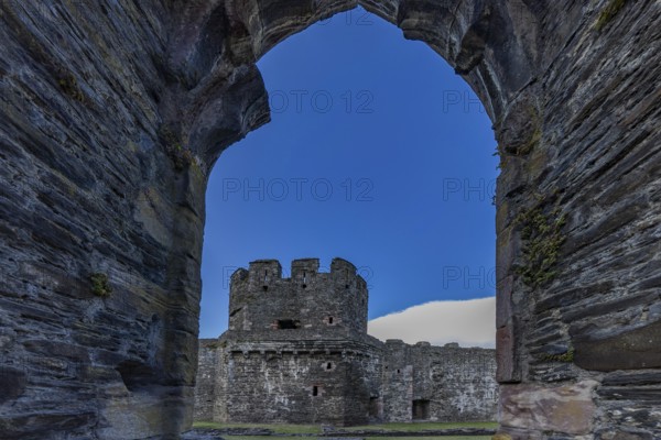 Conwy Castle, view through an arched opening in the castle wall to the tower of the medieval castle with blue sky, Conwy, Wales, Great Britain