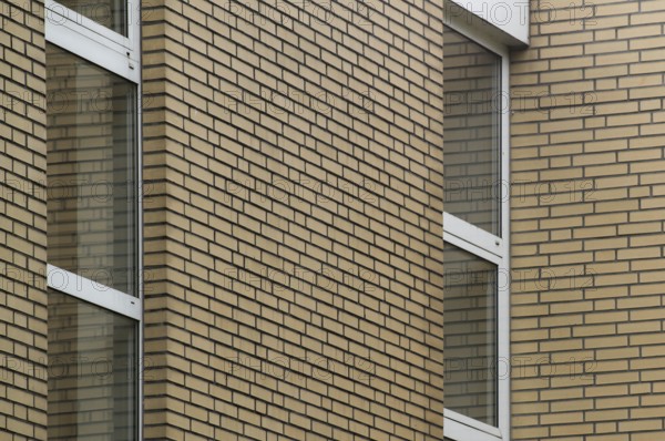 Tan brick wall and windows create a modern and stylish exterior for a building