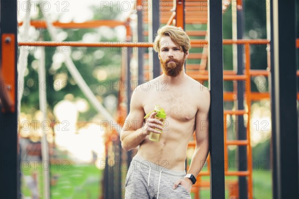 Thirst and health. Sportsman hold water bottle on stadium. Fit man with plastic flask outdoor. Stay hydrated and healthy. Sport and fitness