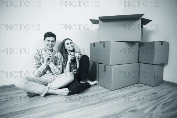 Relocated couple drinking tea on the floor