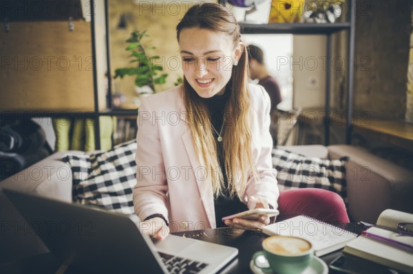 Beautiful Young Freelancer Woman Using Laptop Computer Sitting At Cafe Table. Businesswoman hand typing text, using laptop contact business searching information. Pretty female freelancer working cafe